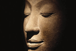 [stone sculpture of Buddha head in meditation]