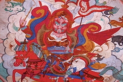 [Tibetan illustration of red figure on red horse with swirling blue and gold, against a background of white clouds]