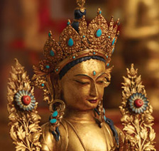 [head and shoulders of golden tara statue with turquoise and coral]